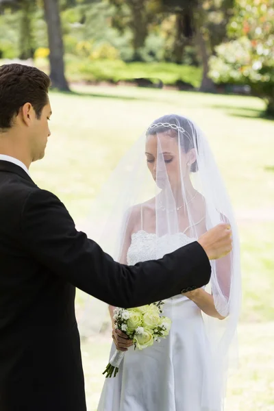 Groom about to lift veil of bride — Stock Photo, Image