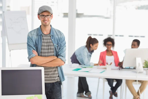 Casual male artist with colleagues in background at office — Stock Photo, Image