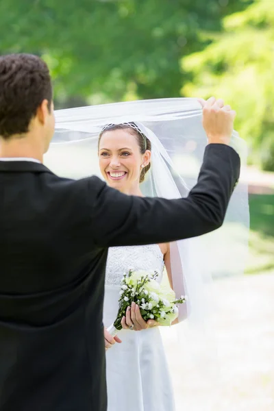 Brudgummen avtäcka sin brud i park — Stockfoto