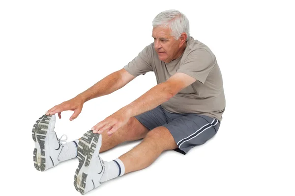 Senior man stretching hands to legs — Stock Photo, Image