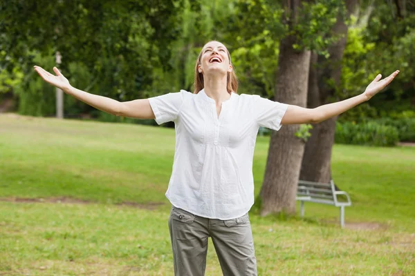 Vrouw met armen gestrekt op park — Stockfoto