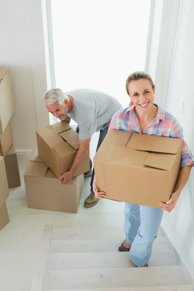 Happy couple carrying cardboard moving boxes — Stock Photo, Image