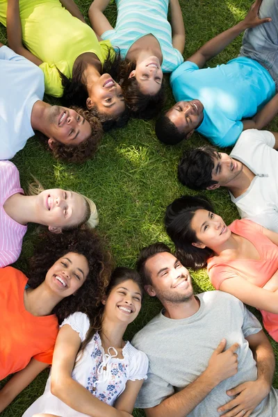 Grupp vänner liggande i park — Stockfoto