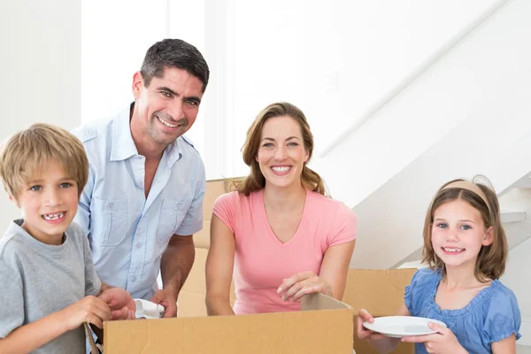 Family unpacking cardboard box — Stock Photo, Image