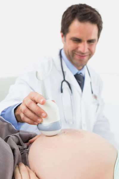 Medico che esegue una scansione ecografica sulla donna incinta — Foto Stock