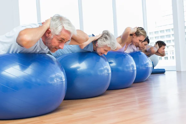 Persone che si allungano su palle di esercizio in palestra — Foto Stock