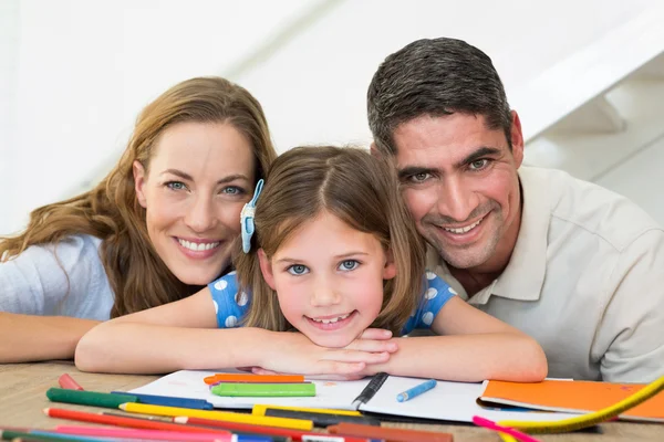 Famiglia con libro e pastelli seduti a tavola — Foto Stock