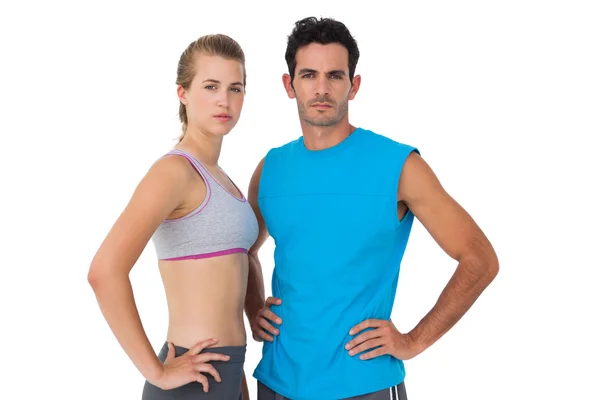 Portrait of a sporty young couple with hands on hips — Stock Photo, Image