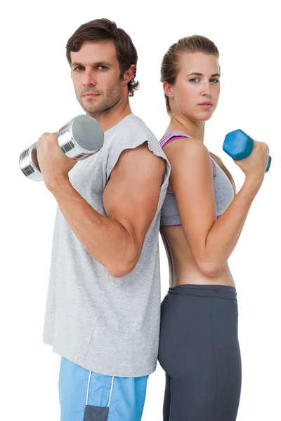 Portrait of a fit couple exercising with dumbbell — Stock Photo, Image