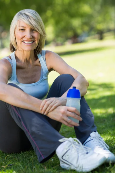 Mujer sosteniendo botella de agua en el parque —  Fotos de Stock