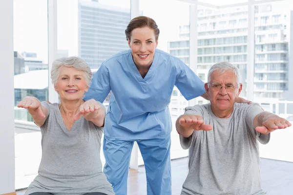 Terapeut hjälpa äldre par med övningar — Stockfoto