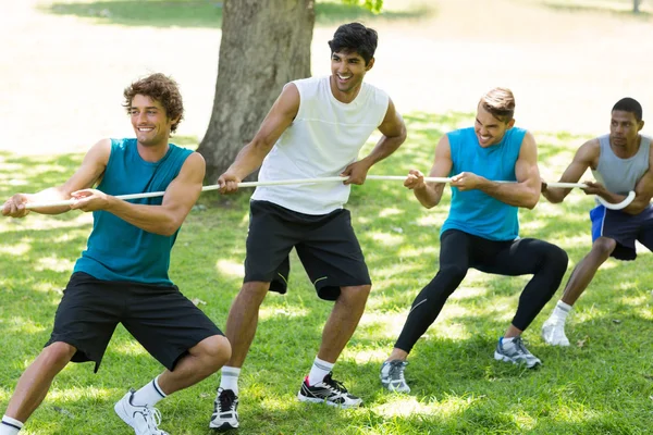 Male friends playing tug of war — Stock Photo, Image