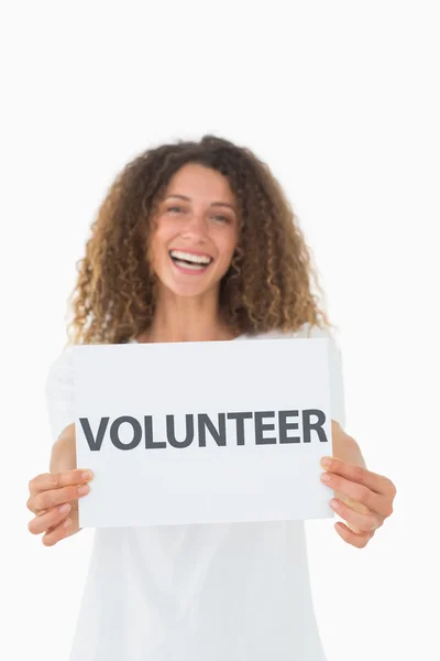 Voluntário sorridente mostrando um cartaz — Fotografia de Stock