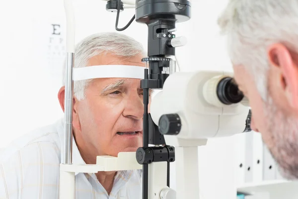 Optometrista haciendo pruebas visuales para pacientes mayores — Foto de Stock