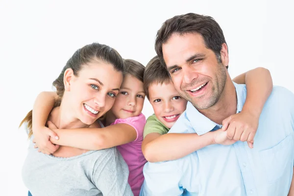 Sorrindo jovem família olhando para a câmera juntos — Fotografia de Stock