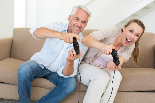 Casal feliz se divertindo no sofá jogando videogames — Fotografia de Stock
