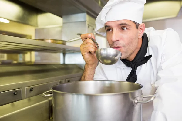 Cook tasting food in kitchen — Stock Photo, Image