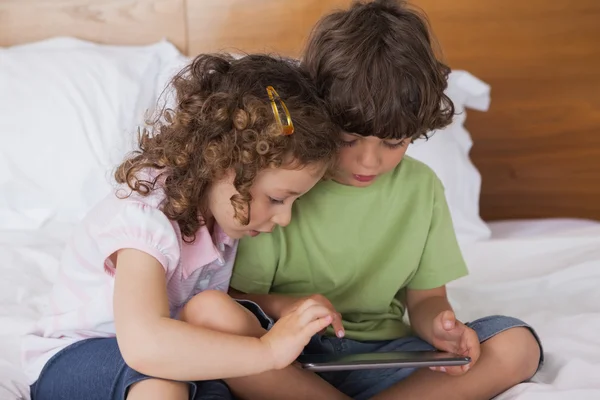 Niño y niña usando tableta digital — Foto de Stock