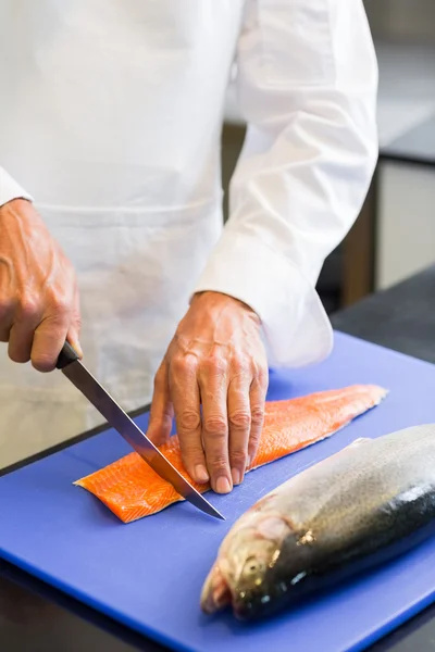 Closeup mid section of a chef cutting fish — Stock Photo, Image