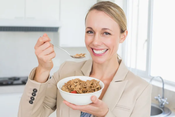 Glad affärskvinna äta spannmål innan arbetet på morgonen — Stockfoto