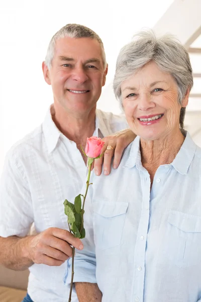 Uomo anziano che offre una rosa al suo partner sorridendo alla telecamera — Foto Stock