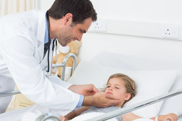 Médico revisando las glándulas tiroideas de la niña enferma —  Fotos de Stock