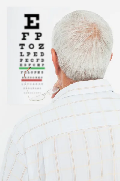 Задний вид пожилого человека, смотрящего на карту глаз — стоковое фото