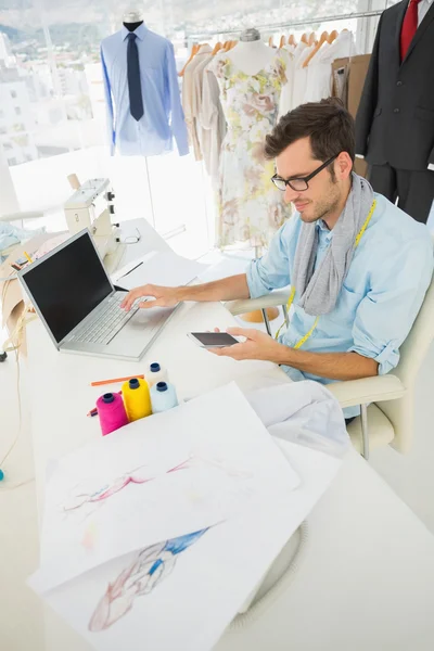 Fashion designer using laptop and cellphone — Stock Photo, Image