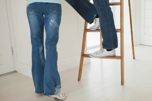 Couple with ladder besides wall — Stock Photo, Image