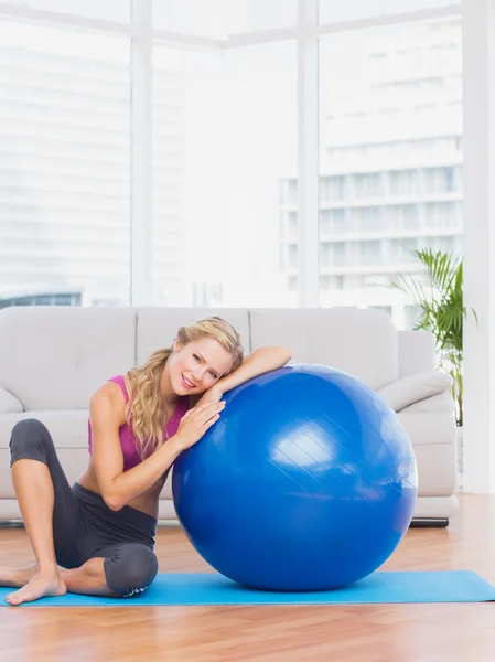 Ajuste rubia sentado al lado de la pelota de ejercicio — Foto de Stock