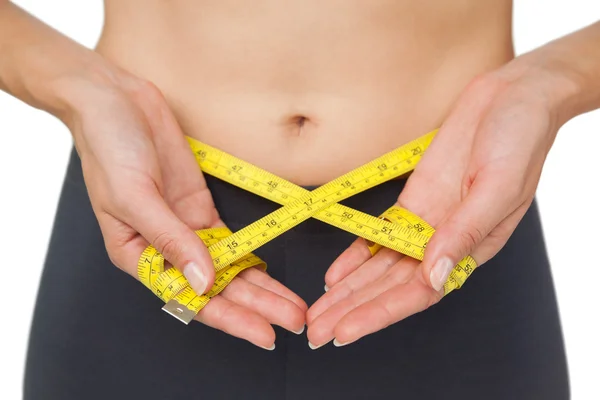 Close-up mid section of a woman measuring waist — Stock Photo, Image