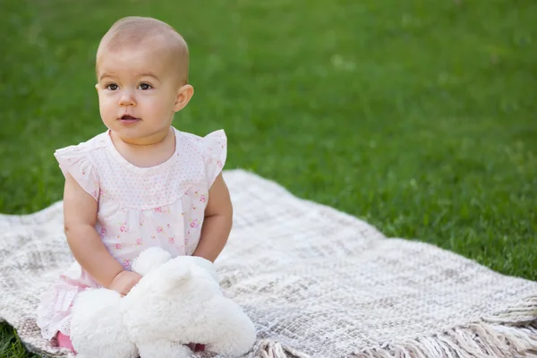 Pelüş oyuncak battaniye parkta oturan bebek — Stok fotoğraf