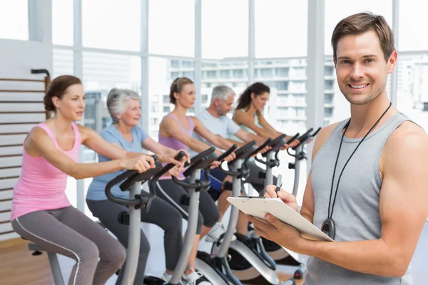 Trainer with people working out at spinning class — Stock Photo, Image