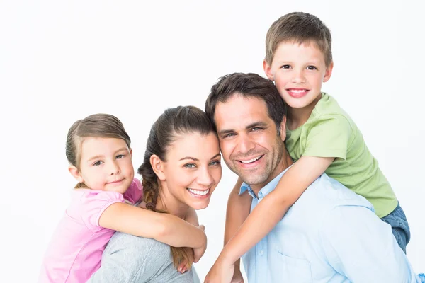 Cheerful young family looking at camera together Stock Photo