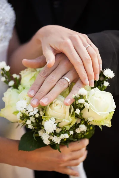 Newlywed couple with wedding rings and bouquet Stock Photo