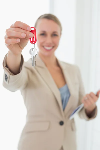 Smiling estate agent showing keys to camera Stock Image