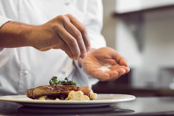 Man adding Salt to served food 