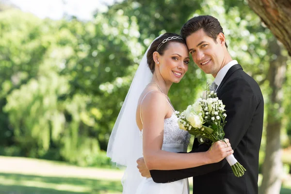 Couple nouvellement marié dans le jardin Image En Vente