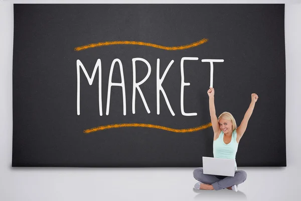 Animando rubia con portátil contra el mercado de la palabra — Foto de Stock