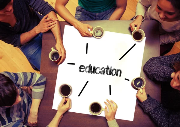 Students sitting around page saying education — Stock Photo, Image