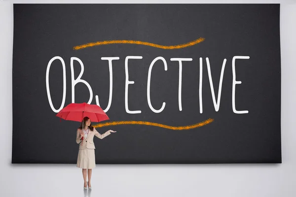 Businesswoman holding umbrella against the word objective — Stock Photo, Image