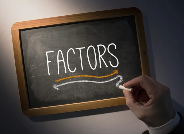 Hand writing Factors on chalkboard — Stock Photo, Image