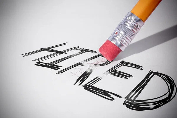 Pencil erasing the word Hired — Stock Photo, Image