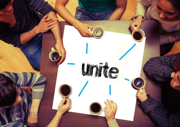 Students sitting around word unite — Stock Photo, Image