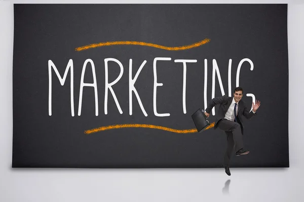 Homem de negócios feliz saltando contra a palavra marketing — Fotografia de Stock