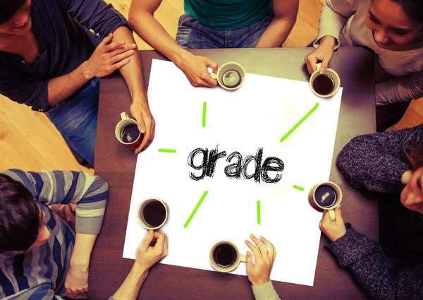 Students sitting around word grade — Stock Photo, Image
