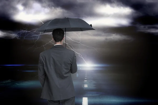 Businessman holding grey umbrella — Stock Photo, Image