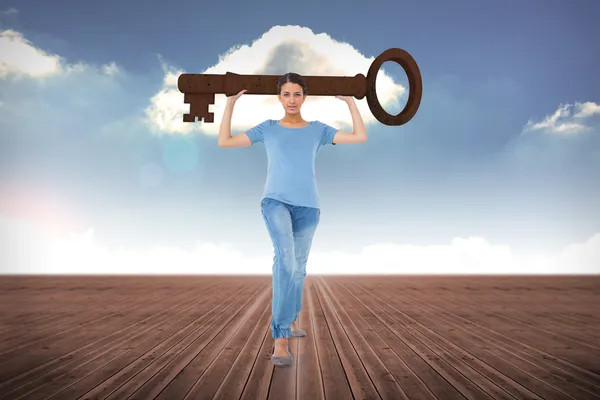 Brunette carrying large key — Stock Photo, Image