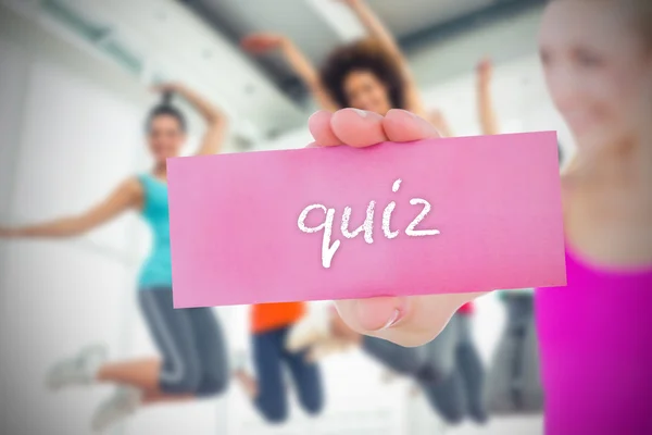 Mujer sosteniendo tarjeta rosa diciendo quiz — Foto de Stock