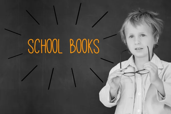 School books against schoolboy and blackboard — Stock Photo, Image